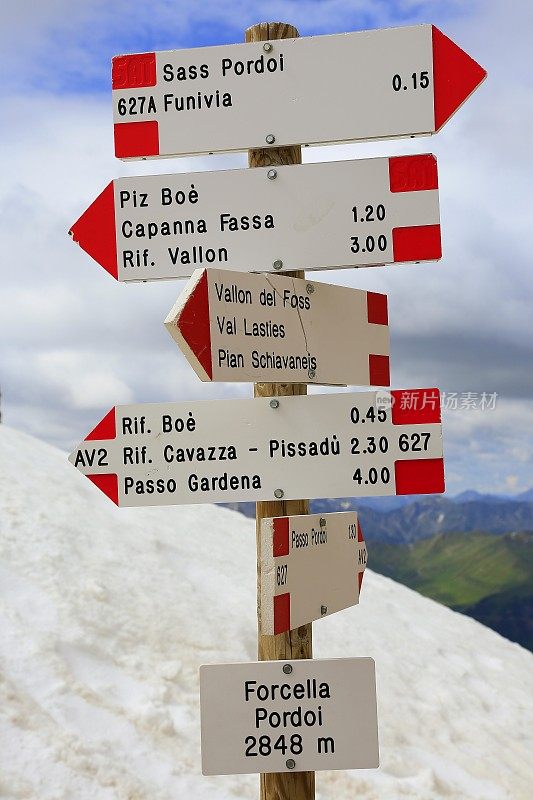 十字路口方向设置标志指向上方田园诗Sas Pordoi和Passo Sella, Langkofel顶峰山丘山脉正面在日出，戏剧性和雄伟的白云石，意大利泰洛阿尔卑斯山